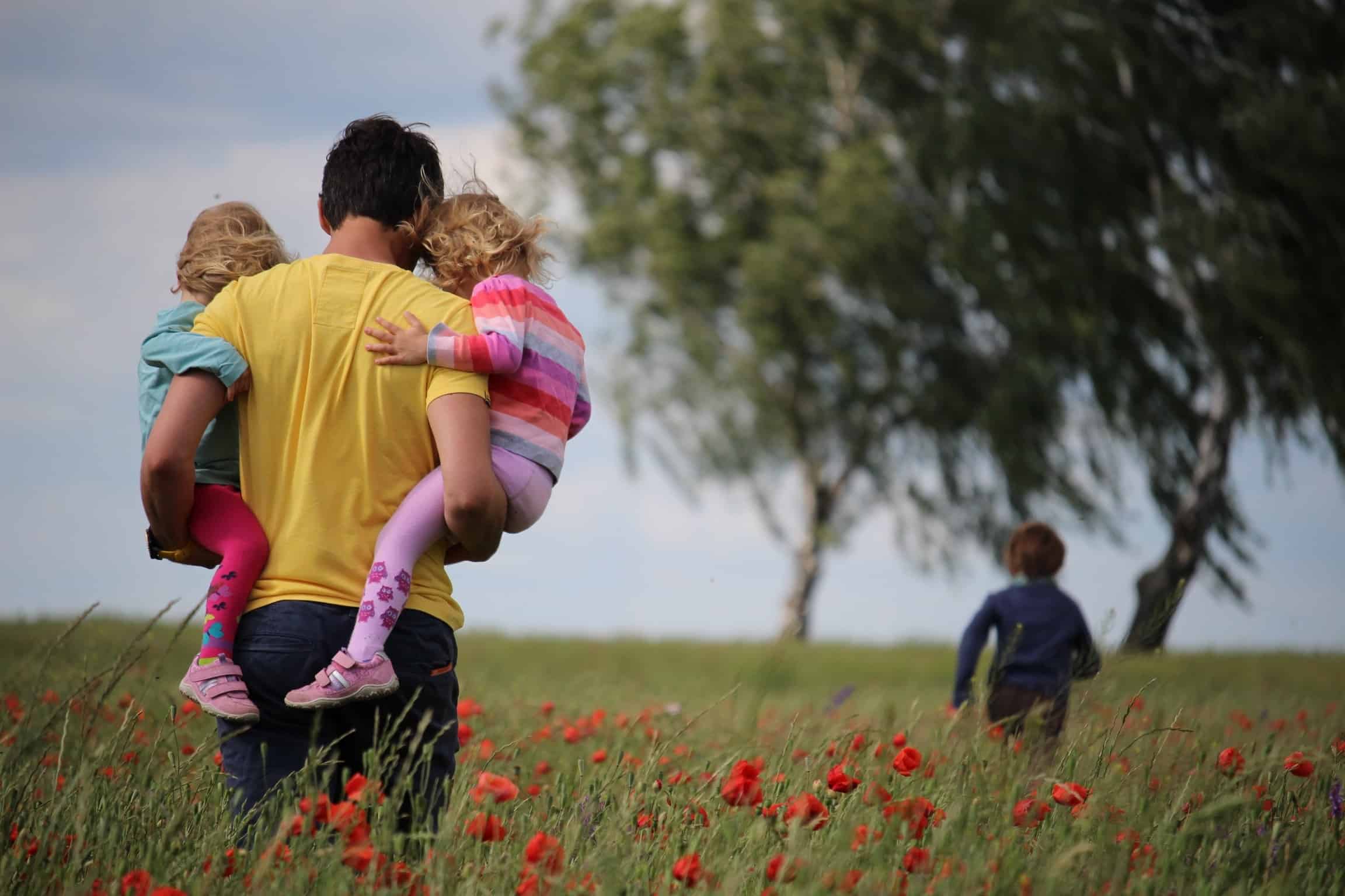 dad and kids in a field
