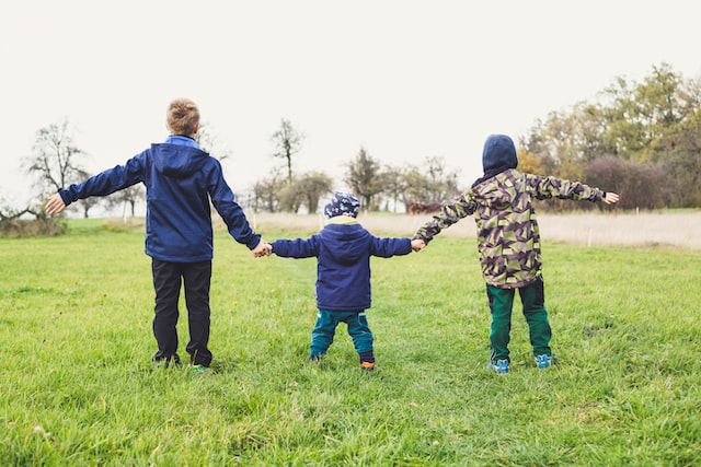 three kids in a field - joyful