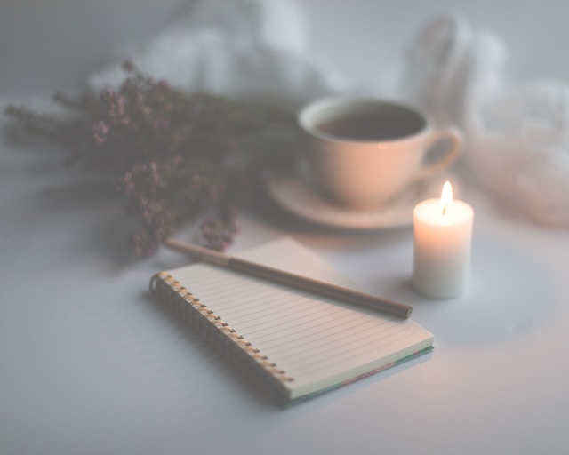 candle, notebook, and coffee
