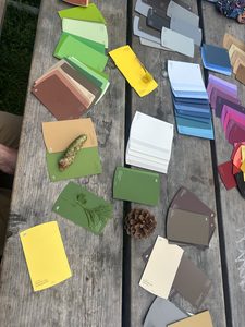 paint chip samples and natural objects on a wooden picnic table for a nature scavenger hunt